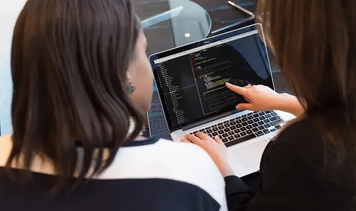 Two women working on a laptop
