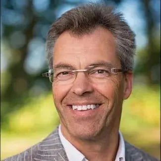 Smiling man with glasses in a grey suit