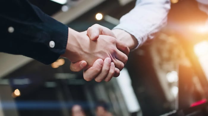 Handen schudden met zonlicht