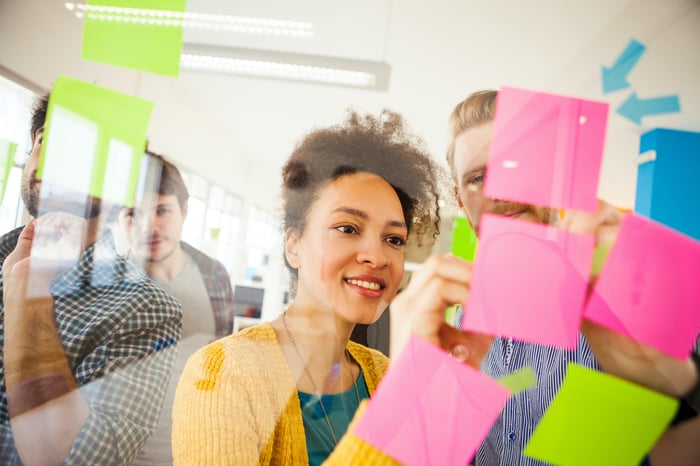 Een vrouw die naar post-it notes kijkt
