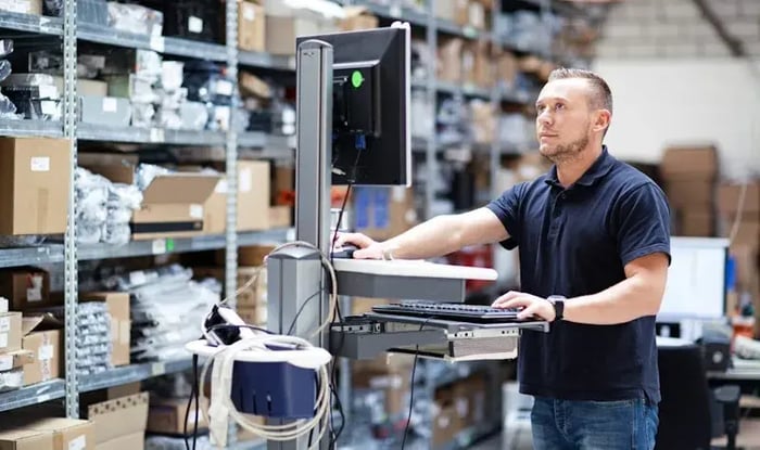 Man staand achter computer