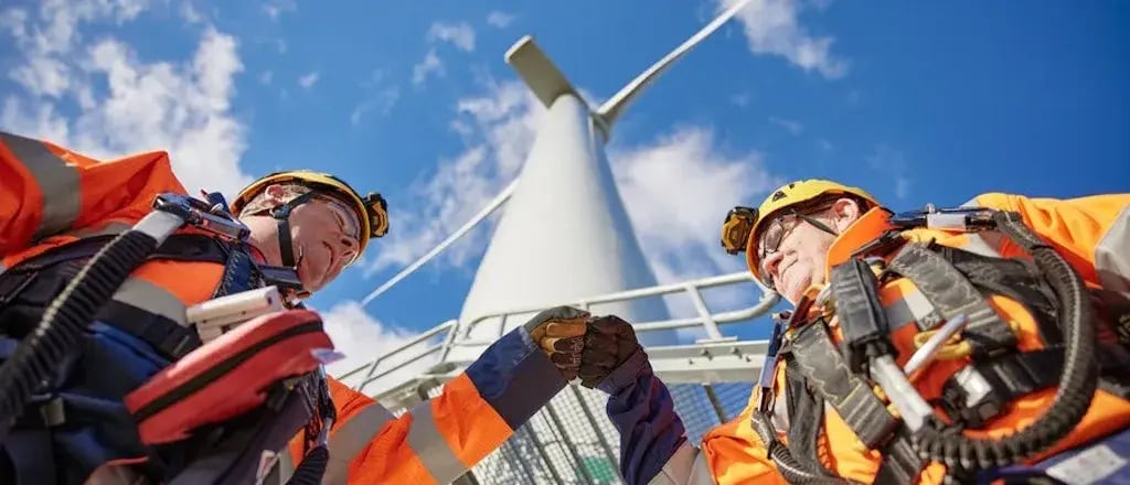 Twee heren van Eneco onder een windmolen.