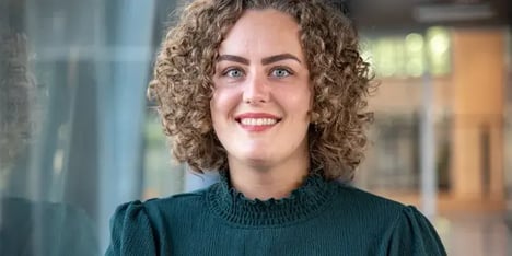 vrouw met krullen lacht in camera