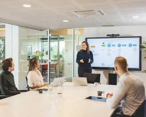 Vier collega's in vergaderruimte.