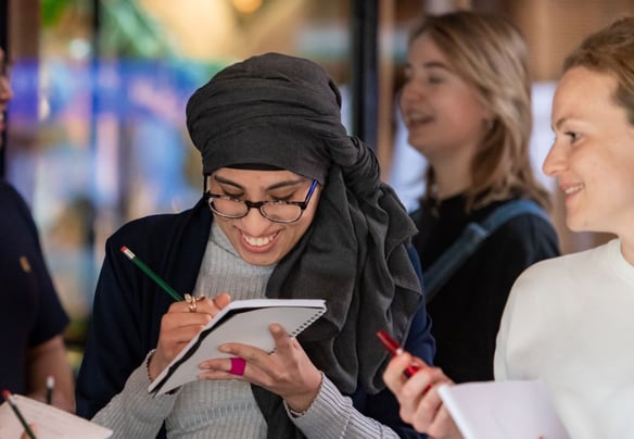 Toya schrijft iets op in haar notitieboek.