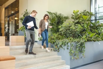 man en vrouw lopen in kantoor trap af