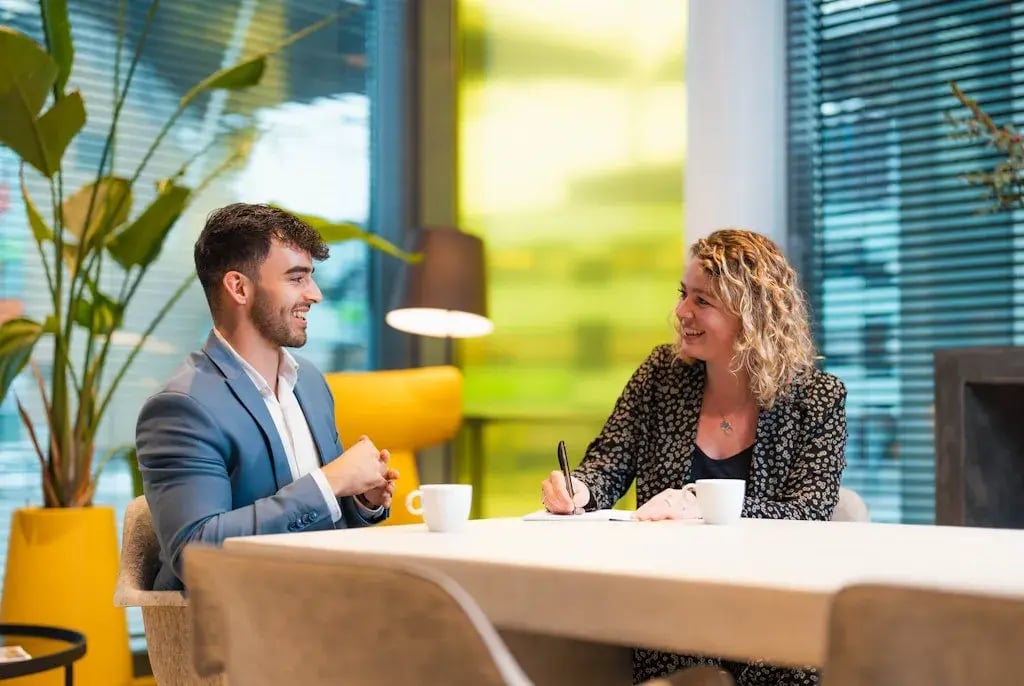 Man en vrouw aan tafel in gesprek