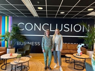 Twee vrouwen staan voor een muur van Conclusion