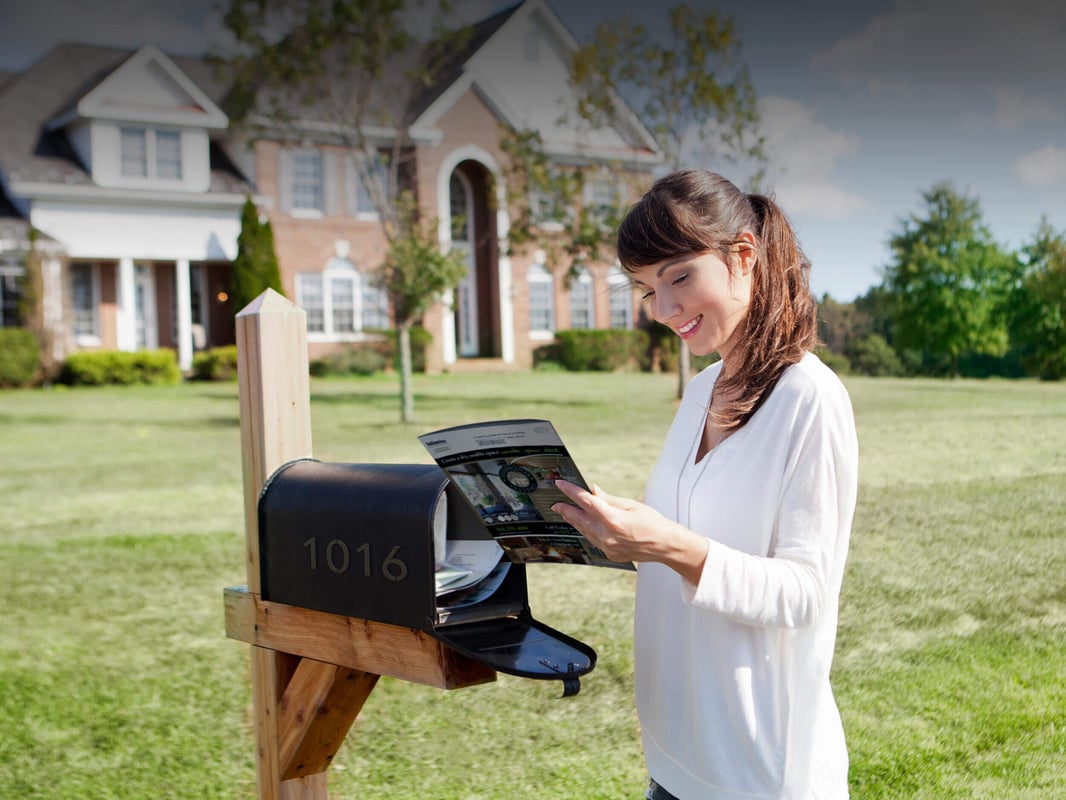 Woman opening mailbox outside her house