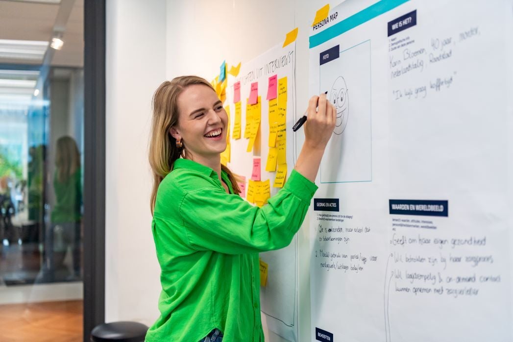 Vrouwelijke collega tekent op een whiteboard.