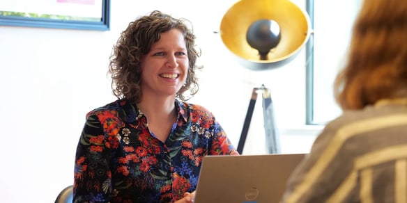 Marije glichtlacht en heeft een laptop voor zich.