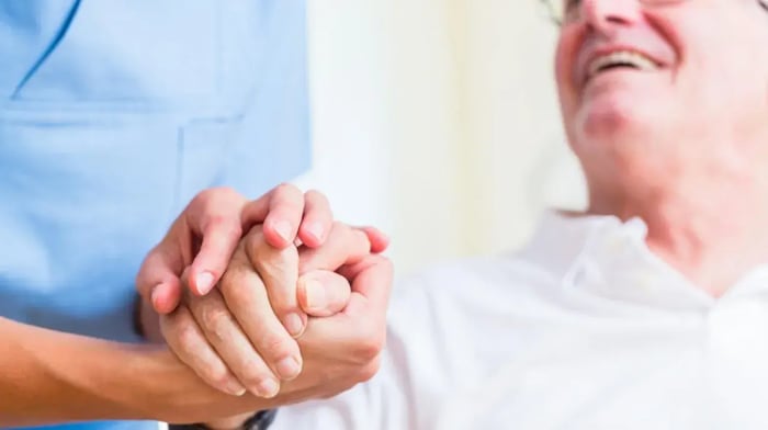 Close up van een verpleegkundige die de hand van een patiënt vasthoudt