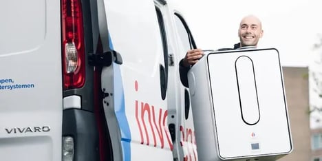 man tilt wasmachine uit busje