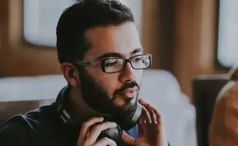 Man doet zijn koptelefoon om zijn nek.