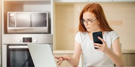 Women with ginger hair working with her laptop and smartphone