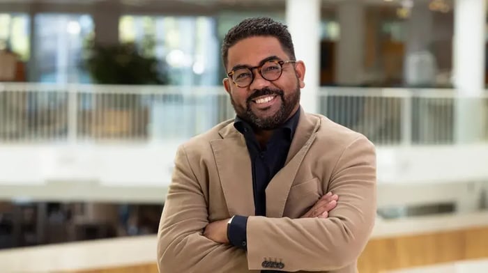 Man with glasses smiles to the camera