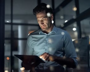 A man is looking on his tablet.
