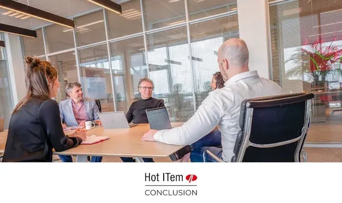 Vier collega's in een vergaderruimte.