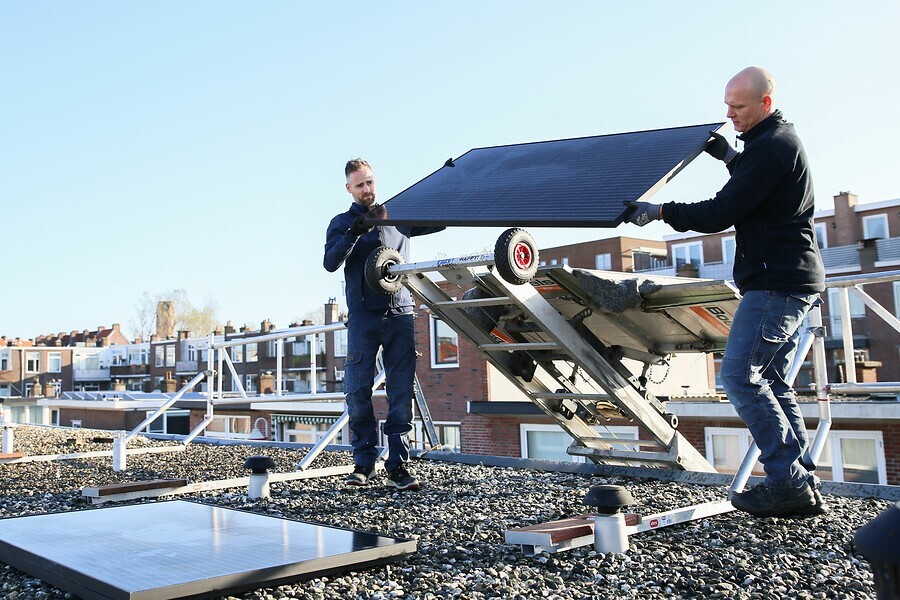 Twee mannen die zonnepanelen plaatsen op een dak