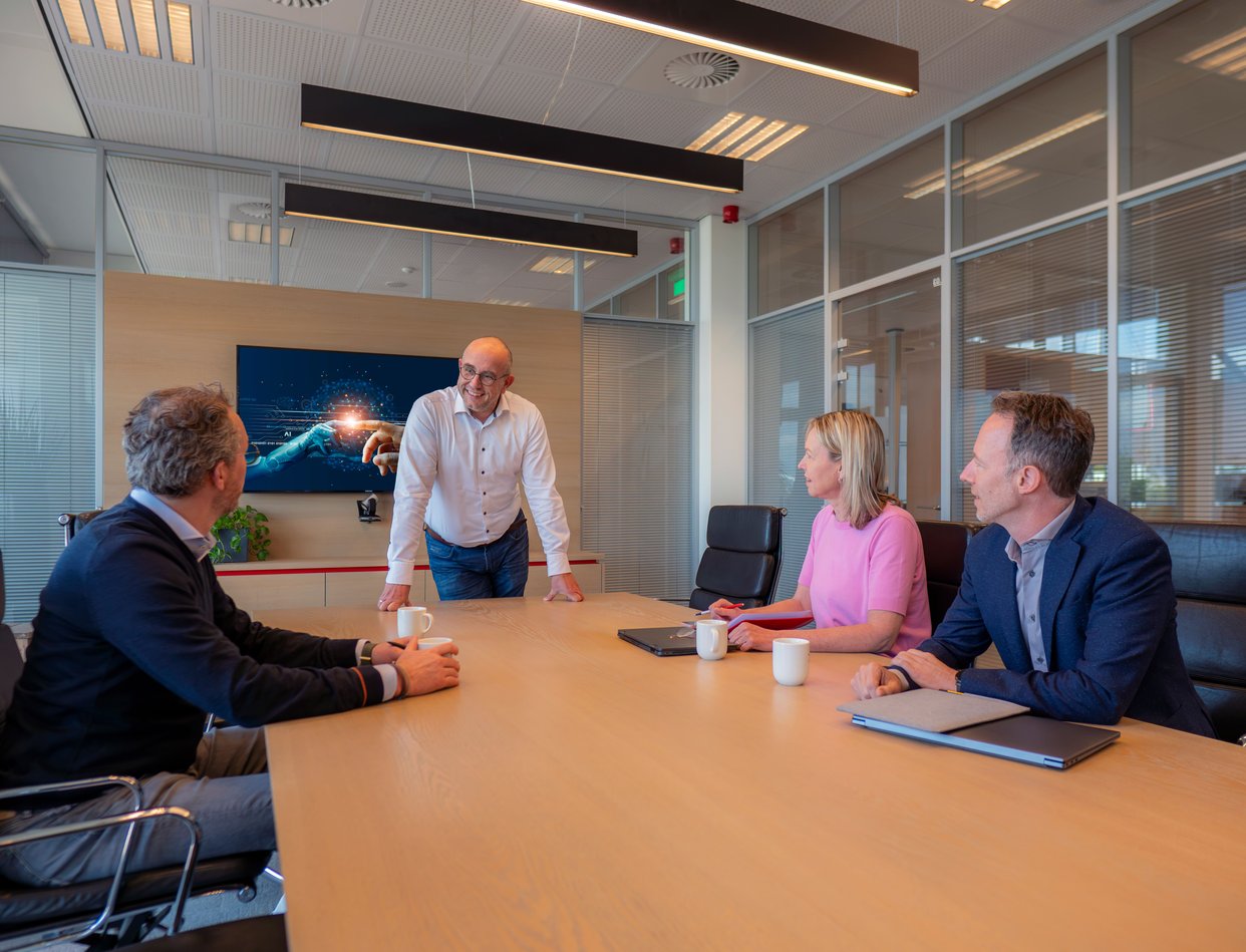 Colleagues in a meeting room talking to each other.