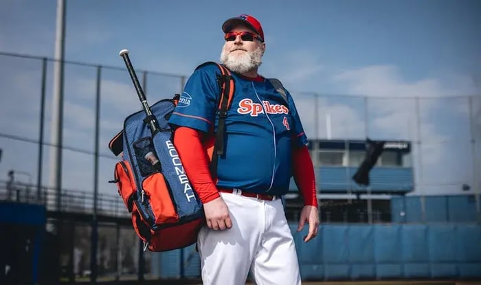 Man in sportkleding en een baard op honkbalveld