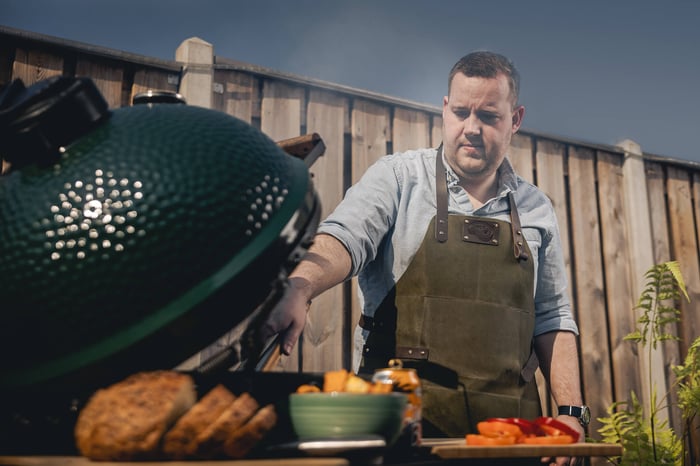 Man bereidt eten met een barbecue.