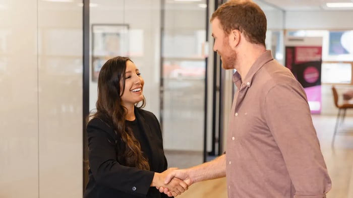 Twee collega's schudden elkaar de hand.
