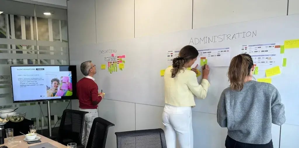 Drie collega's schrijven op een whiteboard