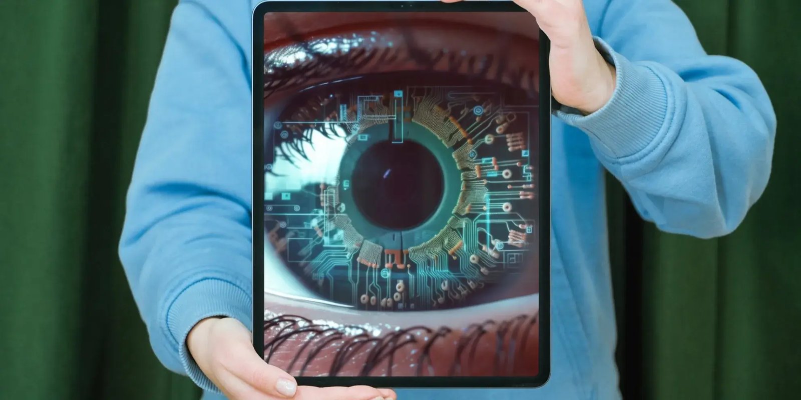 Persoon houdt tablet met grote afbeelding oog met data structuren vast