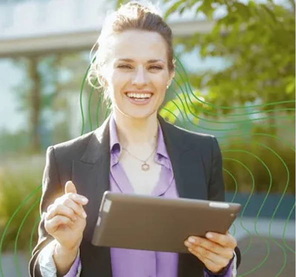 Vrouw met een tablet in haar hand die lachen in de camera kijkt met zakelijke outfit