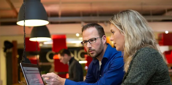 Collegas kijken naar een scherm samen