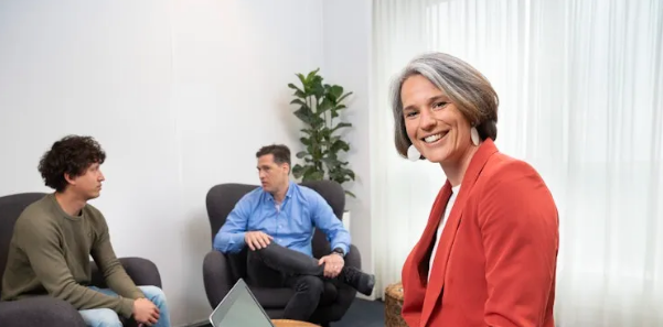 Drie collegas in een kantoor eentje kijkt naar de camera