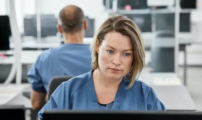 Een mevrouw kijkt naar haar computer