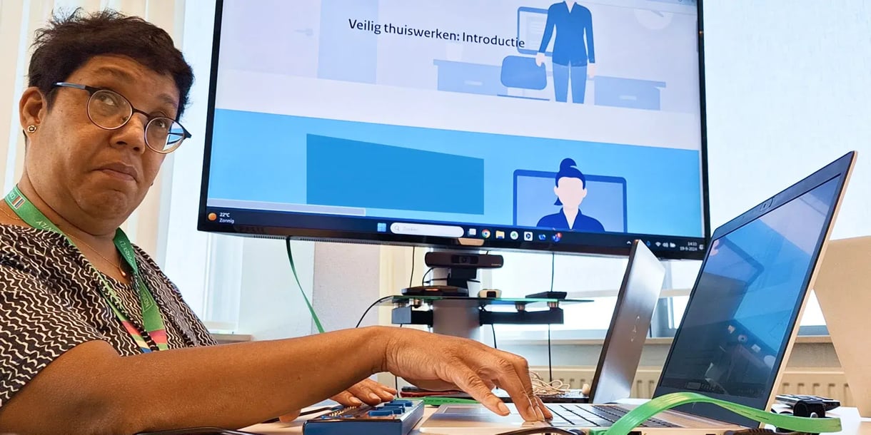 Een mevrouw werkt aan een laptop en kijkt met een grappig gezicht naar de camera-1