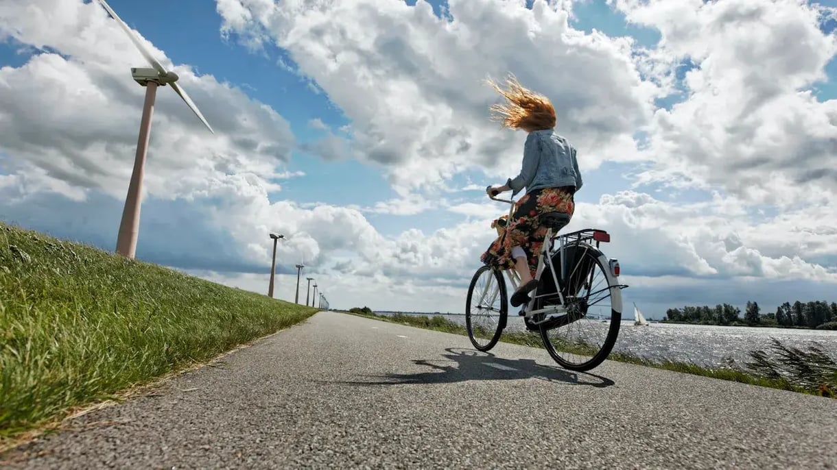 Fietsende vrouw langs windmolenpark Eneco