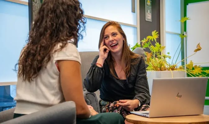 Twee collegas hebben lachend een gesprek