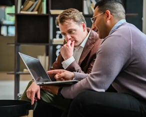 Twee collegas kijken naar een laptop