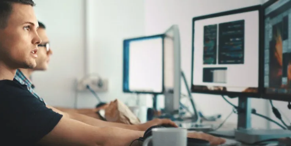 Twee collegas werken achter een scherm