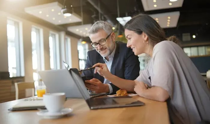 Twee collegas werken vrolijk samen