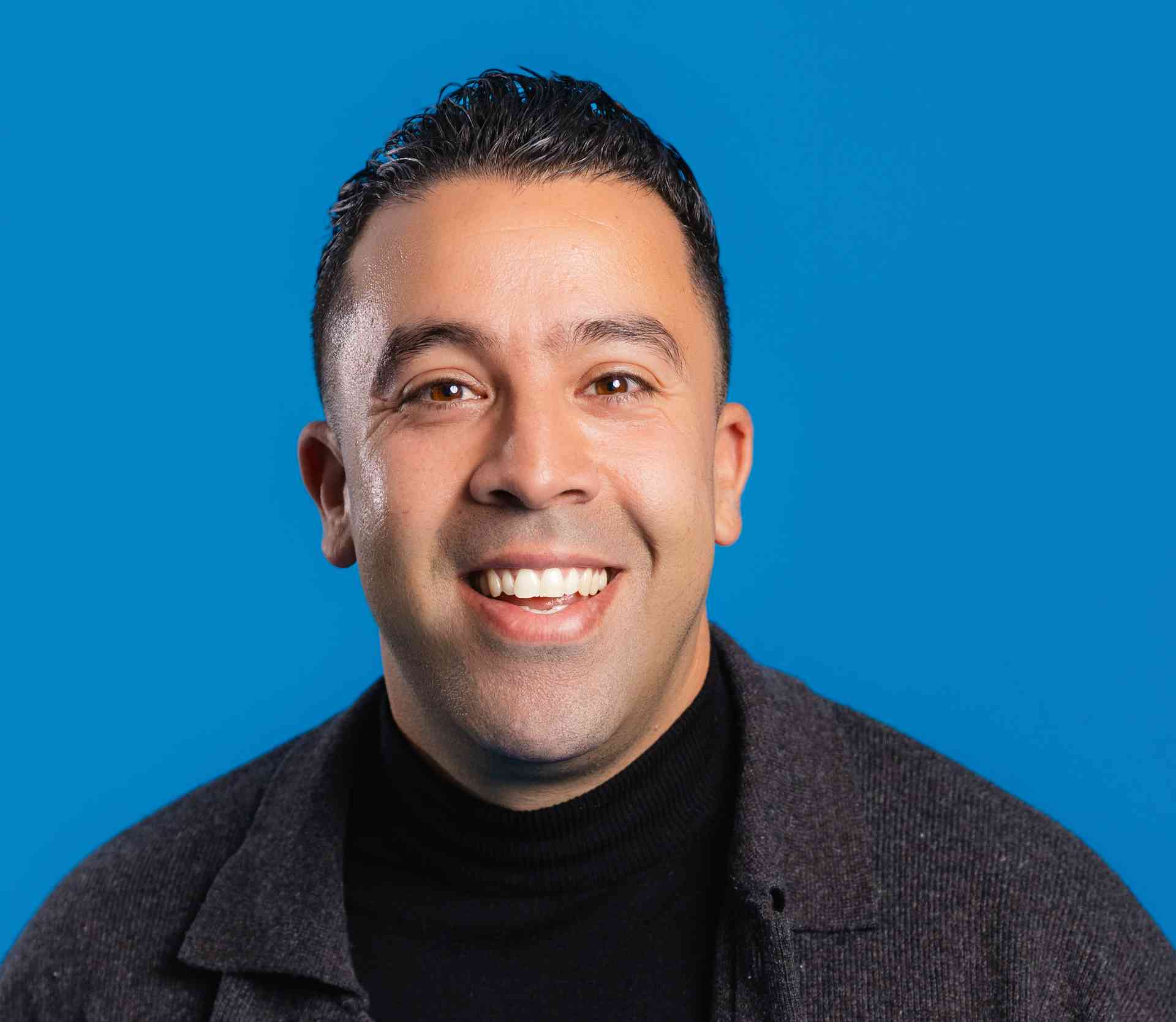 Man kijkt lachtend in camera.