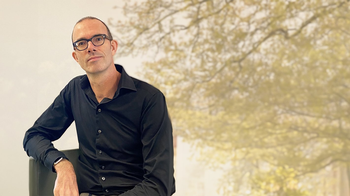 Michiel Tebbes kijkt omhoog met een boom in de achtergrond