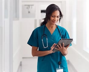 Jonge verpleegkundige die op een tablet kijkt in het ziekenhuis