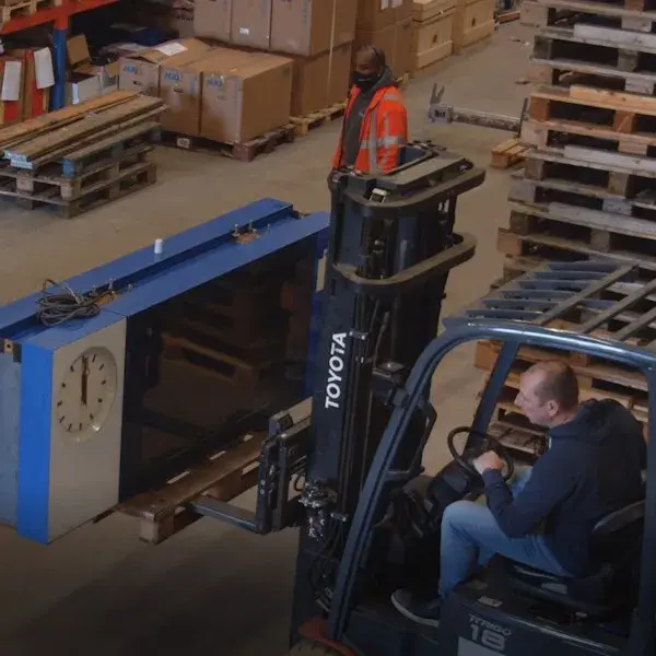 Collega met een informatie bord op een heftruk