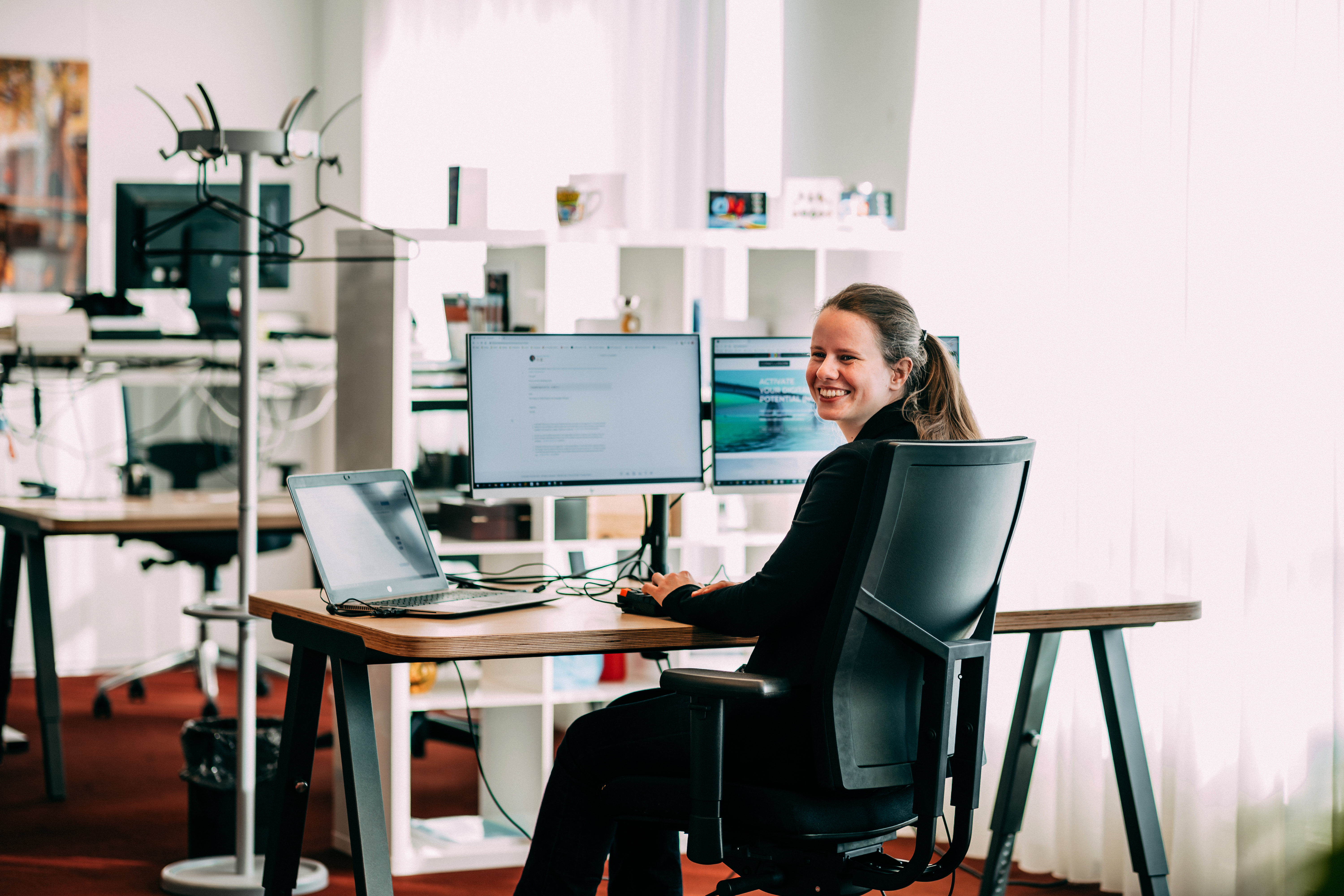 Lachende vrouw zittend aan een bureau