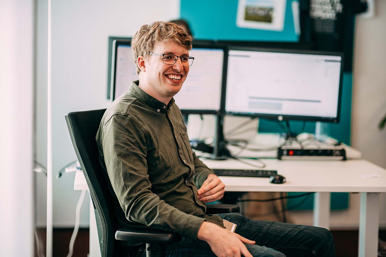 Lachende man zittend in bureaustoel