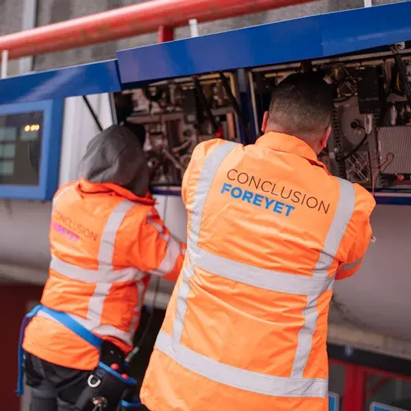 mensen in oranje hesjes werken aan de trein