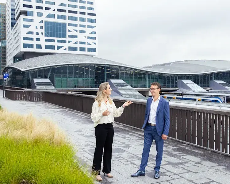 Twee collega's staan op het dak van een gebouw.