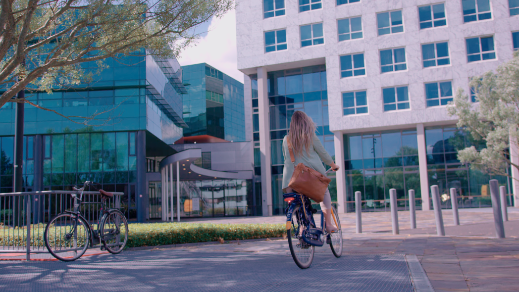 Vrouw fietst richting gebouw