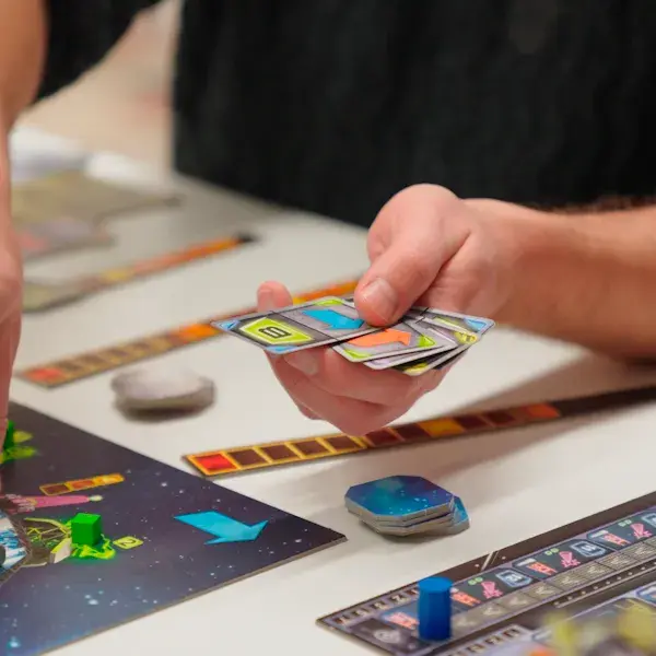 Bordspel op tafel met een hand die kaartjes vasthoudt