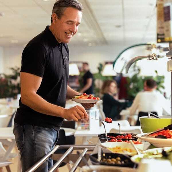 A male colleague is choosing food from a buffet.